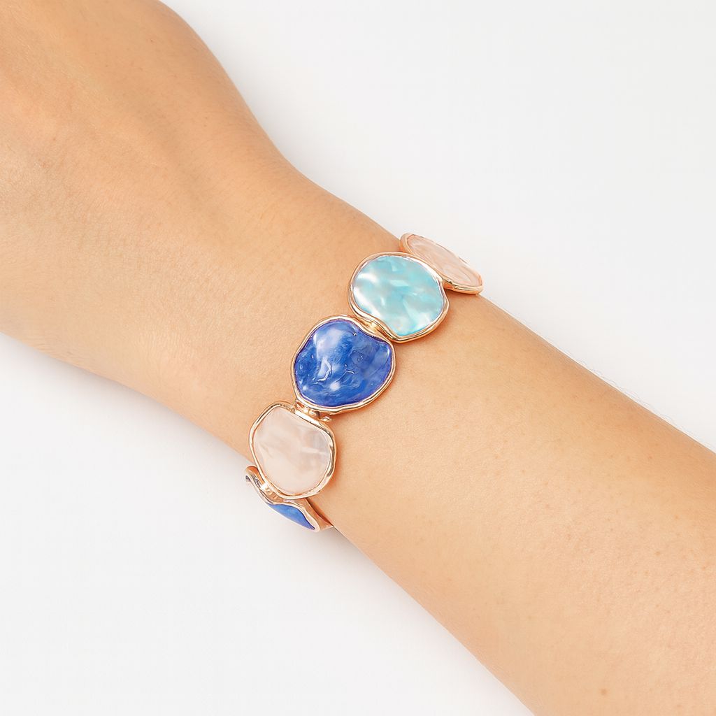 Model wearing hand-painted swirl bracelet in gold