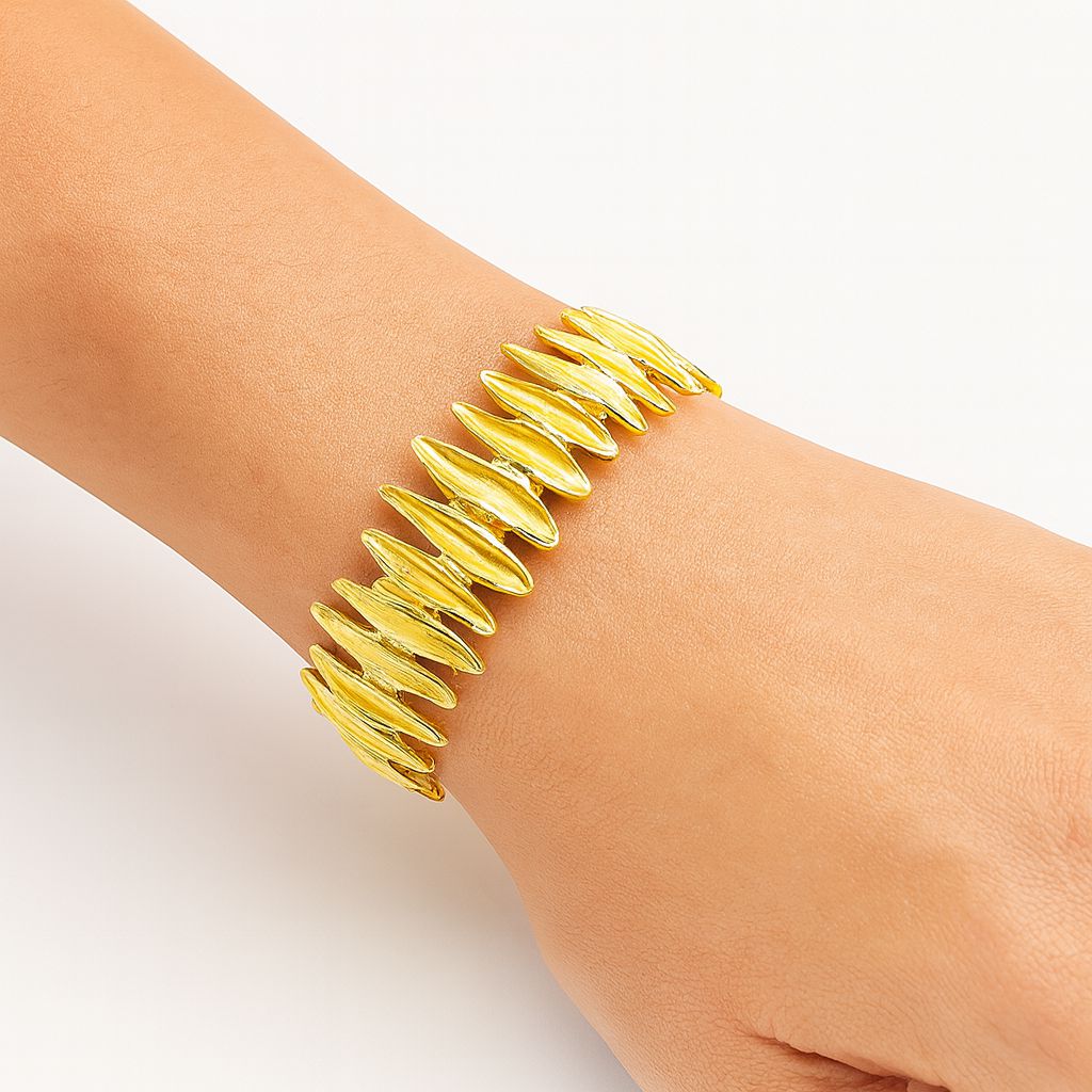 “close-up of textured KC gold bracelet with hand-painted design”