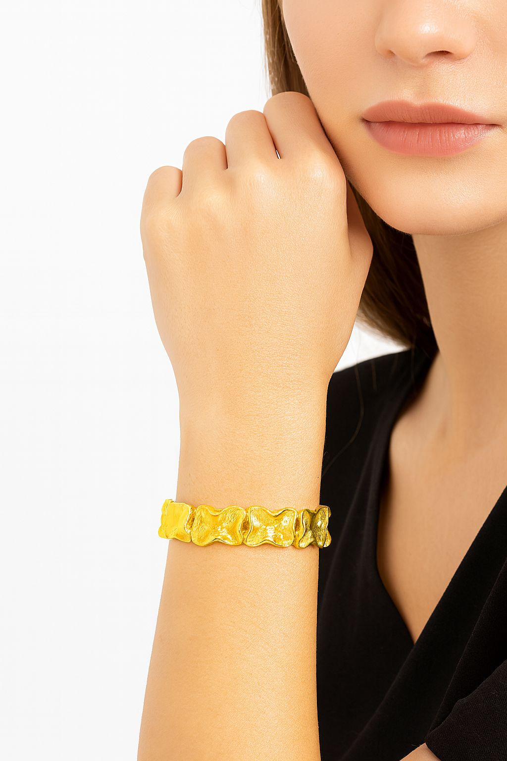 Textured gold plated geometric bracelet on wrist, hand-painted alloy statement jewelry