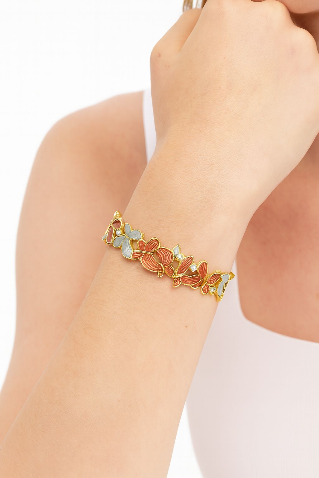 Model wearing gold butterfly enamel bracelet on wrist