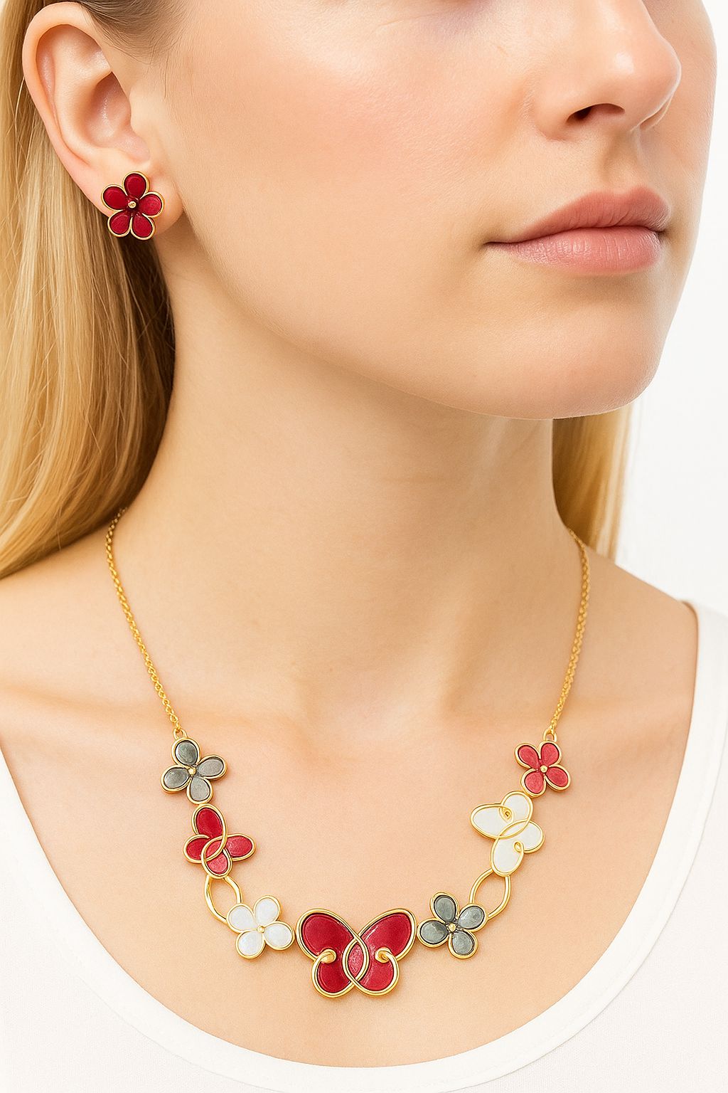 Model wearing floral and butterfly enamel necklace with matching earrings