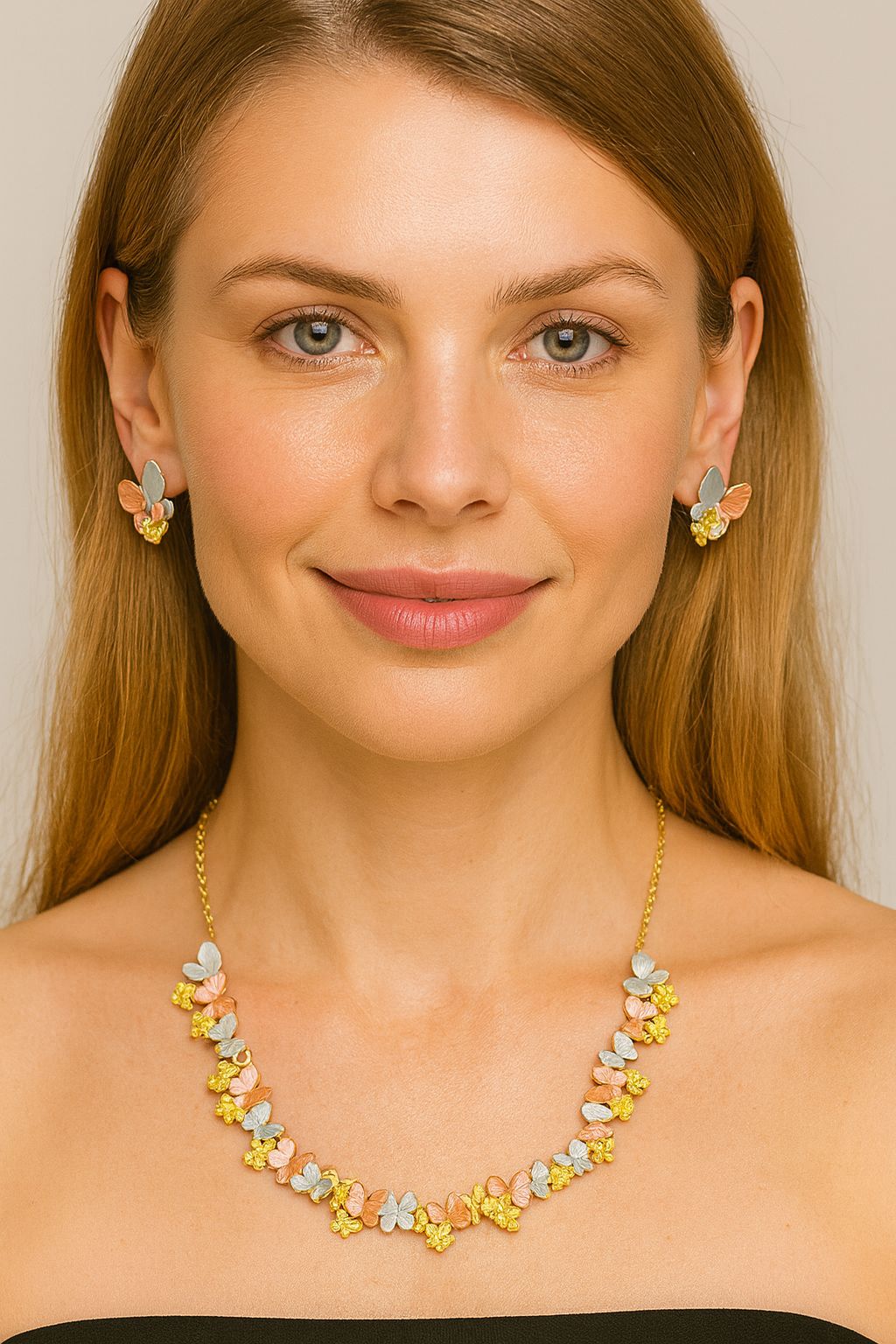Model wearing butterfly blossom necklace and earrings set in gold and enamel
