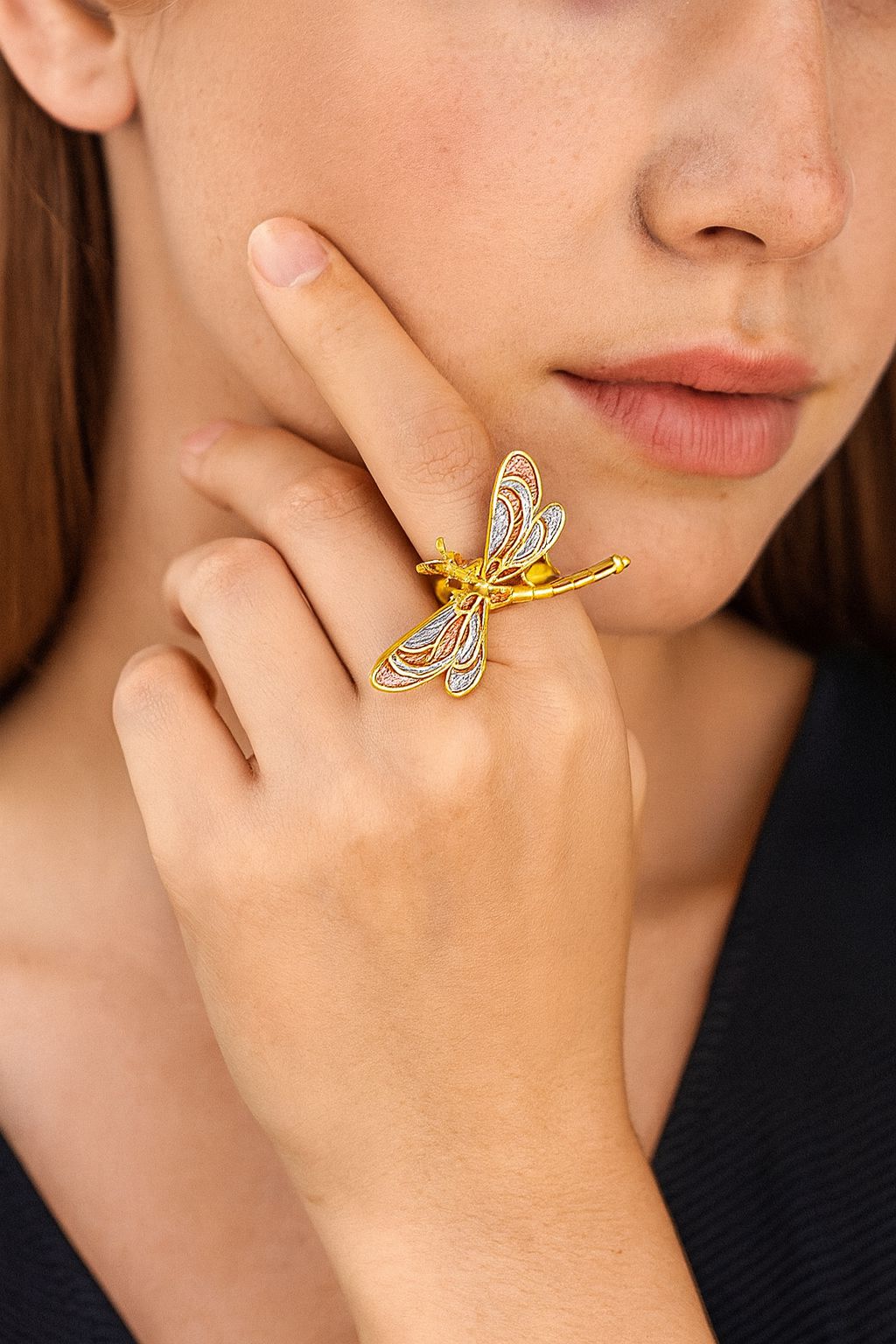 Adjustable dragonfly ring worn on hand for size reference
