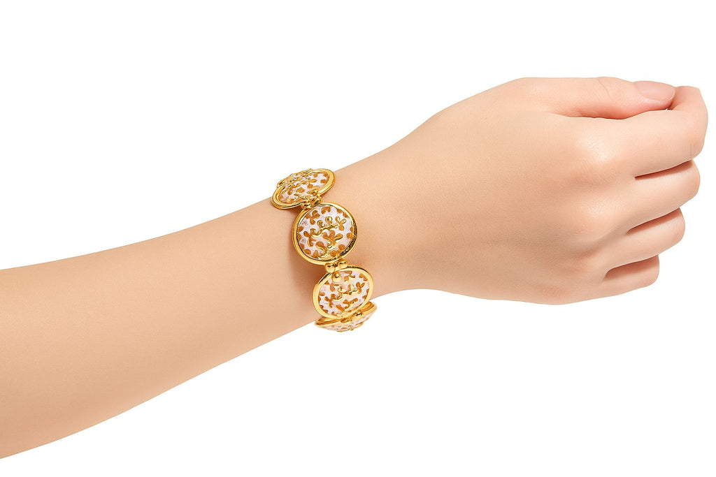 Close-up of enamel art gold bracelet on woman's wrist