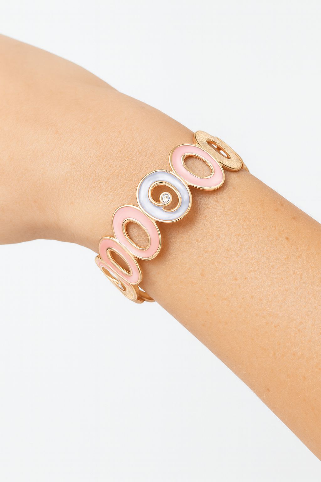 Close-up of enamel heart bangle showing pastel colors and gold finish