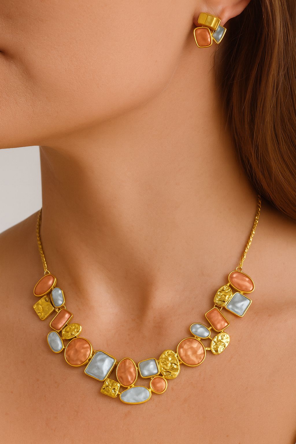 Close-up view of geometric KC gold plated earrings with pastel stones