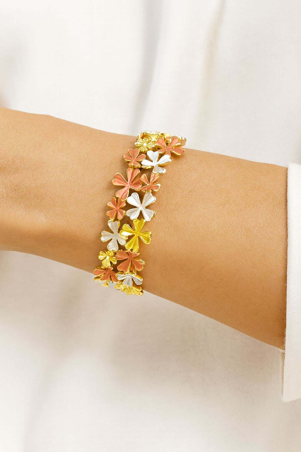 Gold floral enamel bracelet worn on wrist