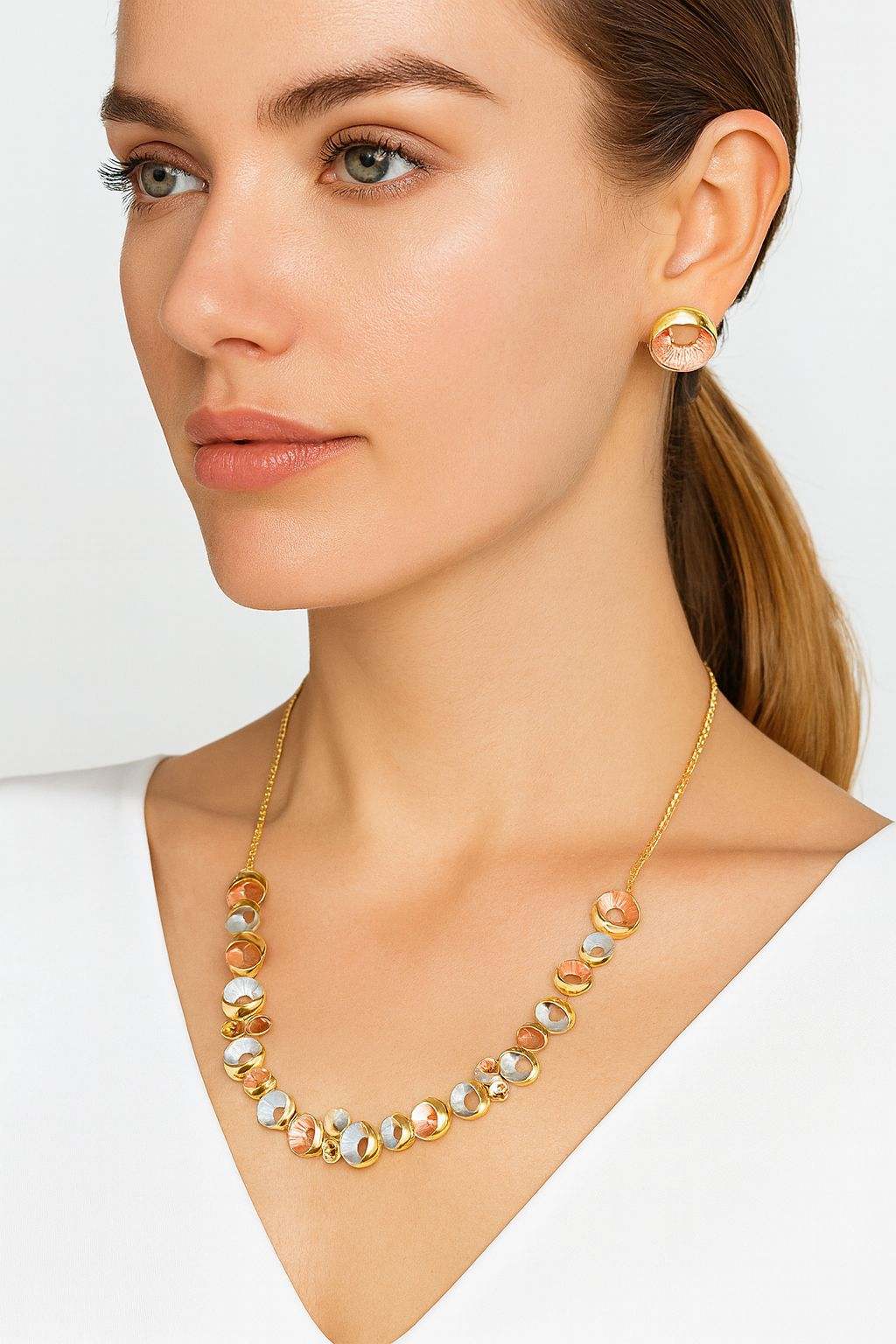 Woman wearing women's gold circle jewelry set with multi-tone gold, rose, and silver circle necklace and matching earrings