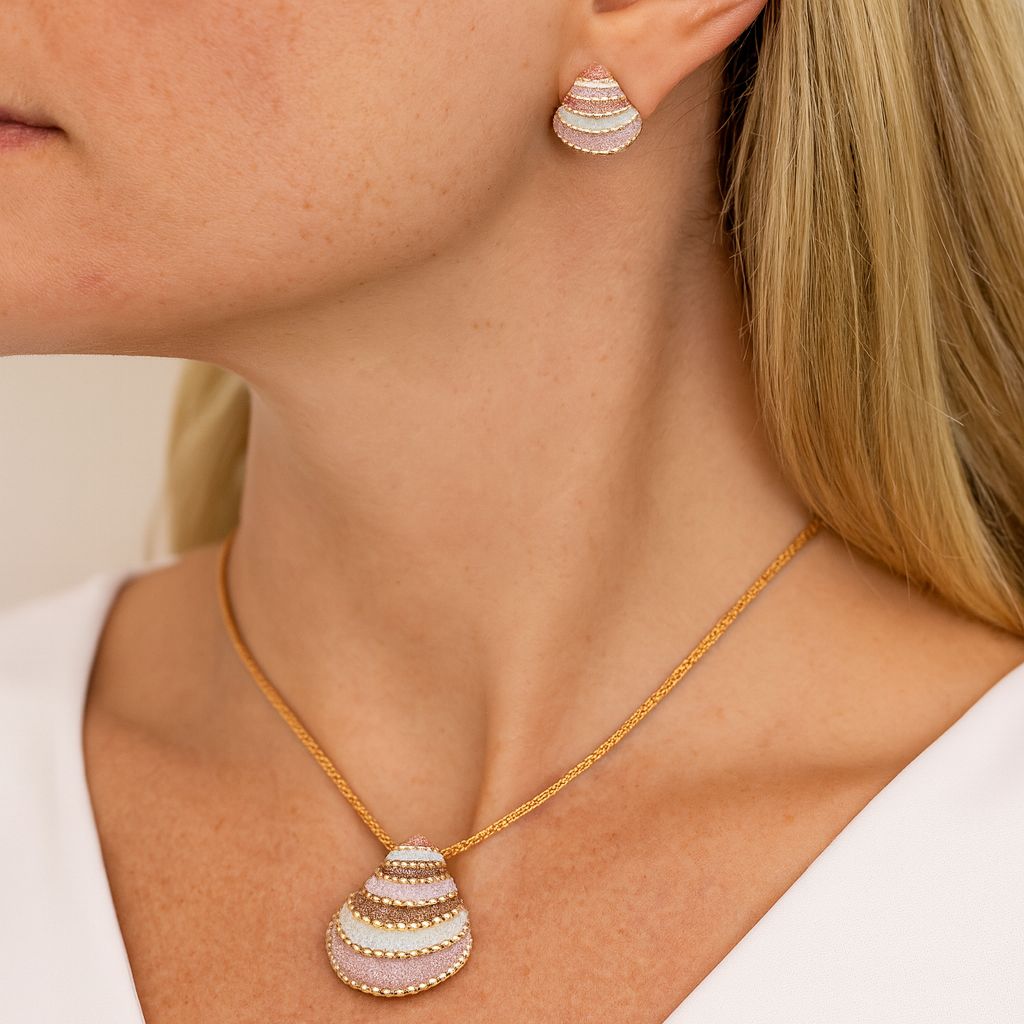 Close-up of gold tone shell-inspired earrings with hand-painted enamel