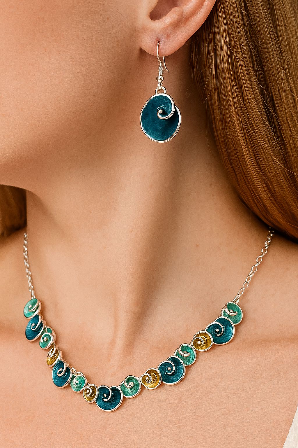 Artistic enamel swirl necklace and earrings worn by model