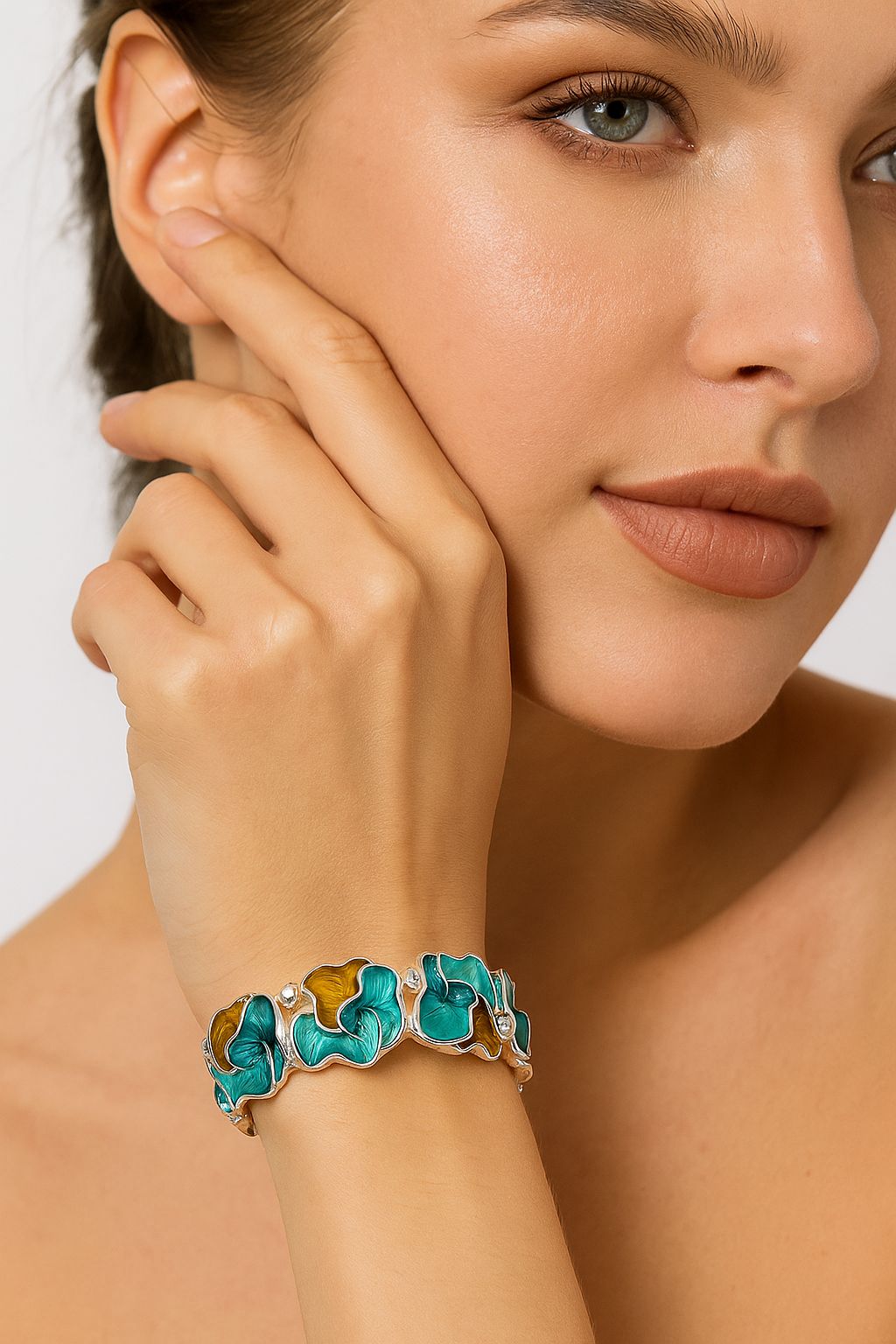 Vibrant turquoise and amber enamel petal bracelet worn on wrist.