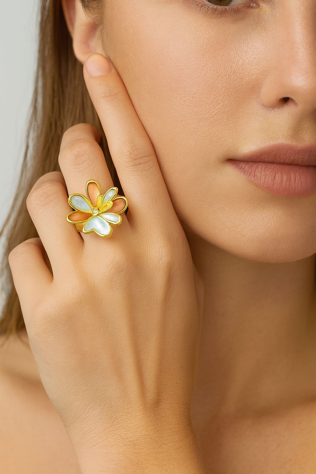 Detail of artistic enamel petal design on gold-plated flower ring