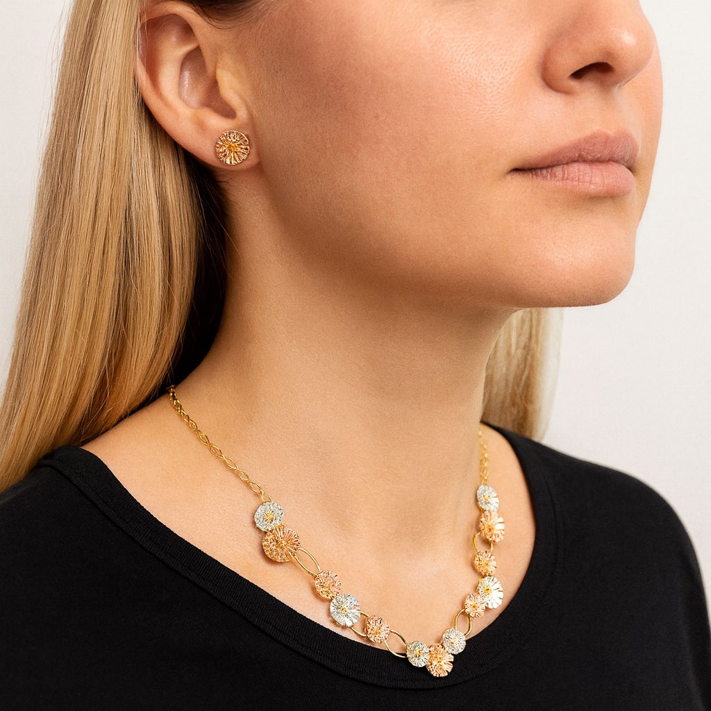 Model wearing gold floral necklace and enamel earrings