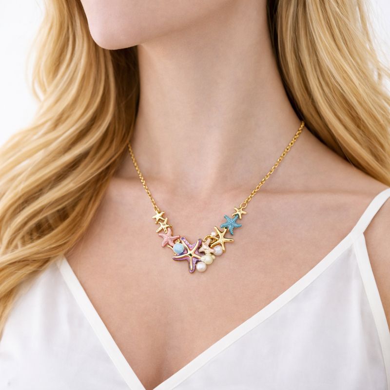 Close up of hand painted starfish earrings with KC gold plated finish