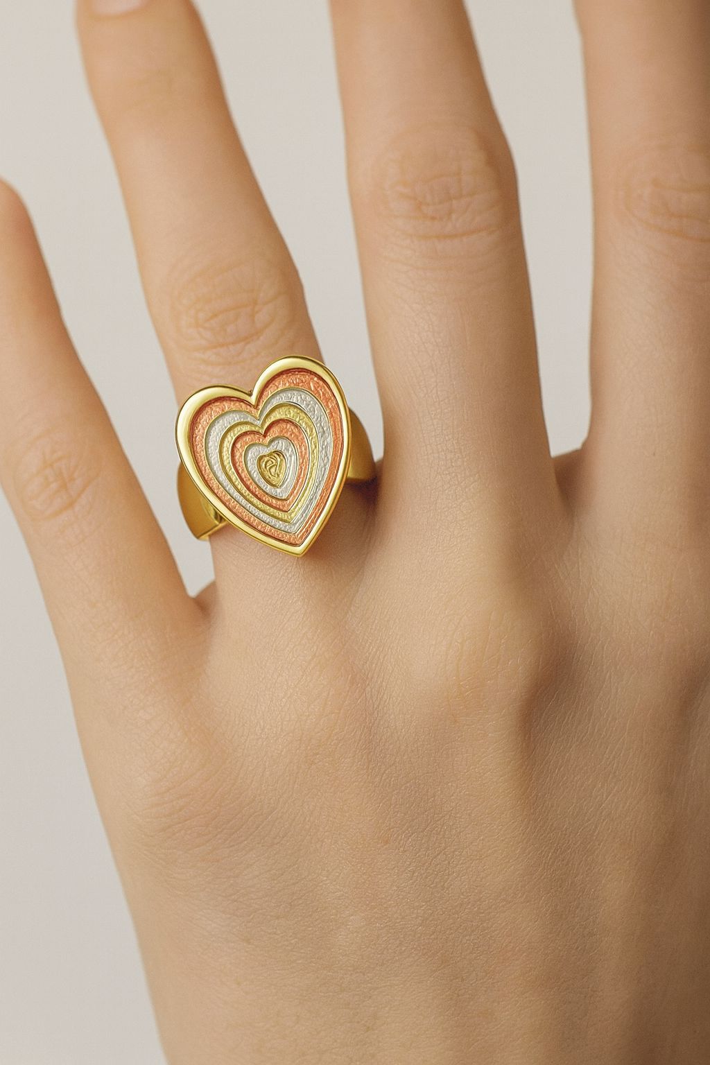 Artistic multicolor heart statement ring in KC gold on model’s hand