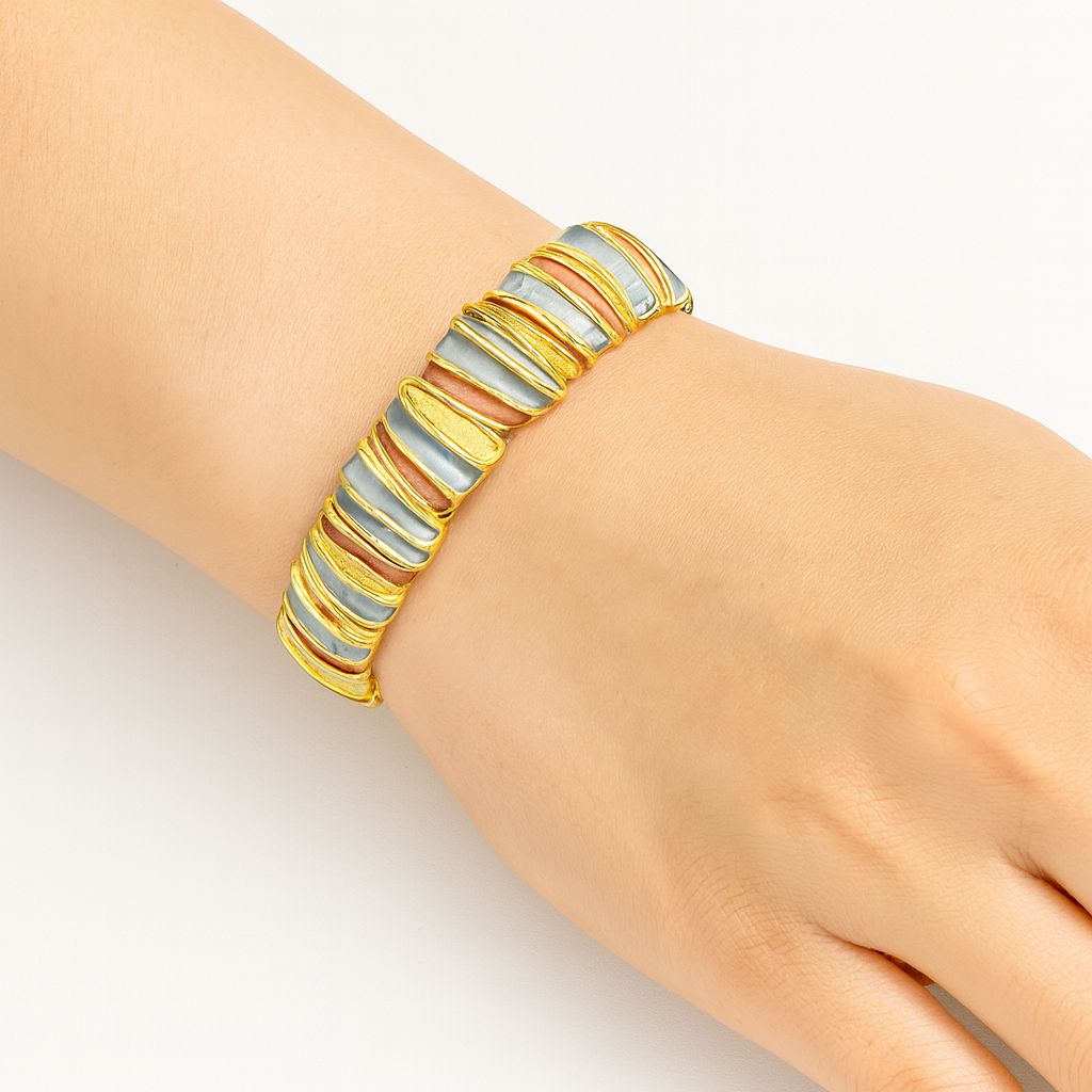 Close-up of textured enamel gold bangle with hand-painted details