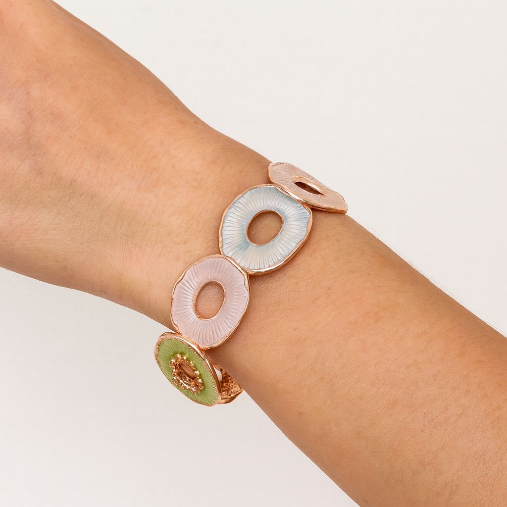 Woman wearing hand-painted enamel circle bracelet in KC gold with pastel colors