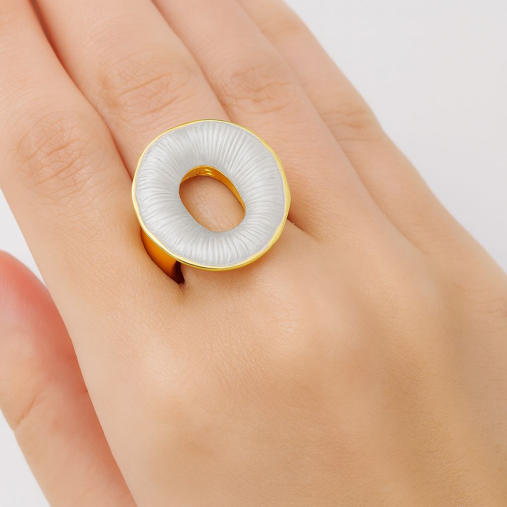 Close-up of artistic round gold fashion ring with textured enamel finish