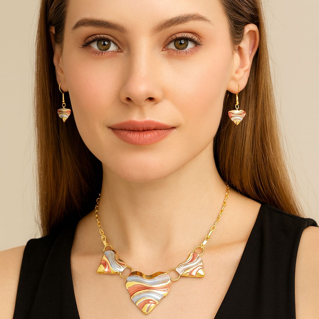 Model wearing gold heart earrings and matching necklace