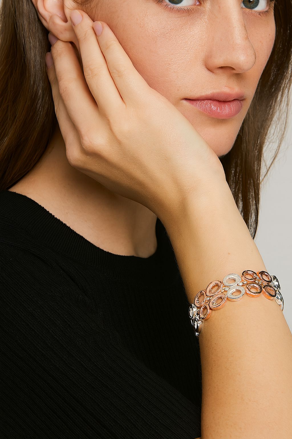 Woman wearing geometric circle-link KC gold bangle set