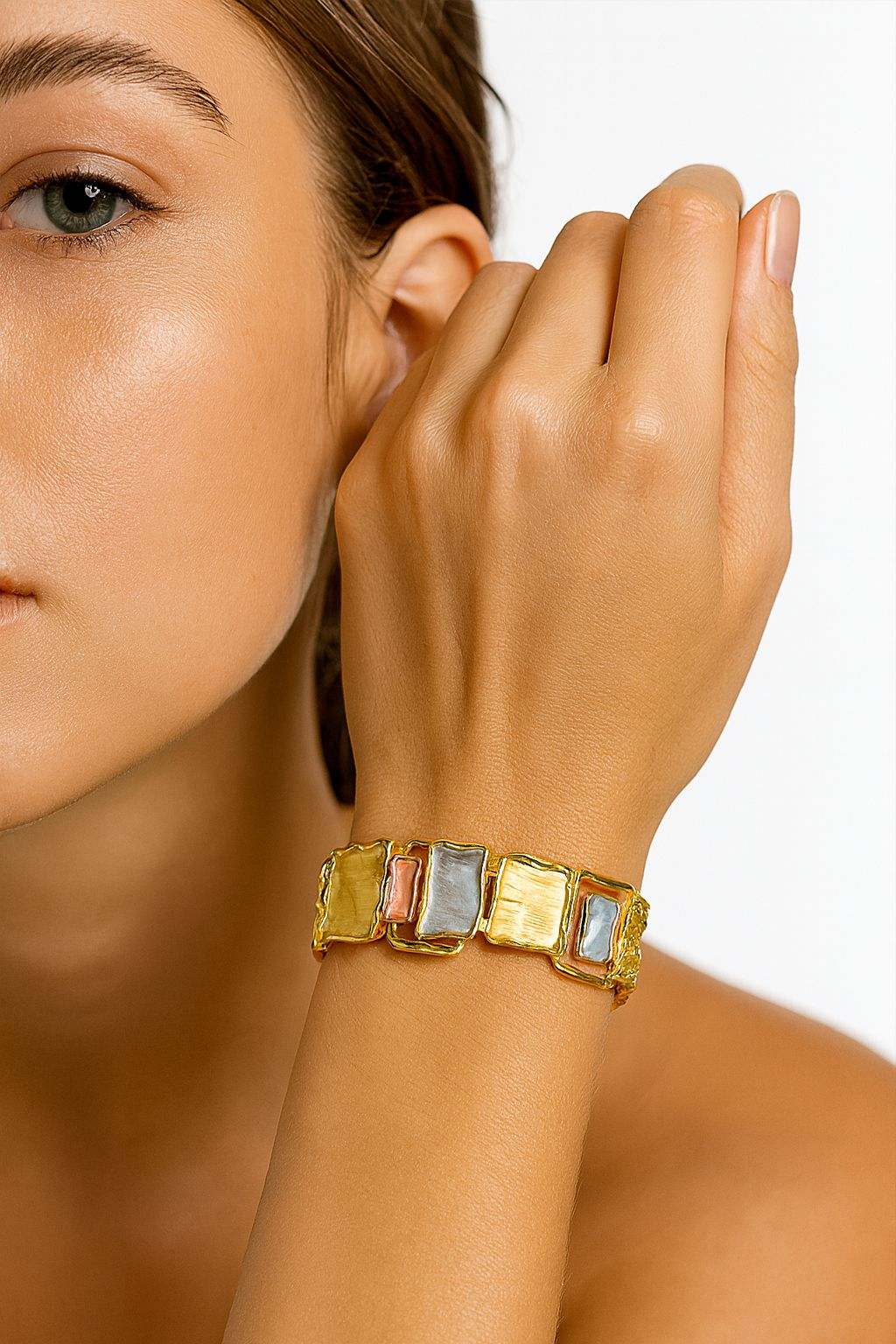 Woman wearing gold-plated rectangle bracelet with multicolor hand-painted charms