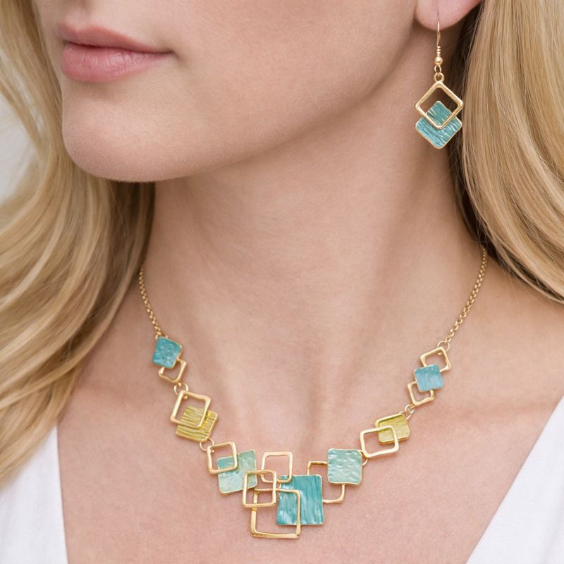 Close up of KC gold plated enamel necklace with artistic details