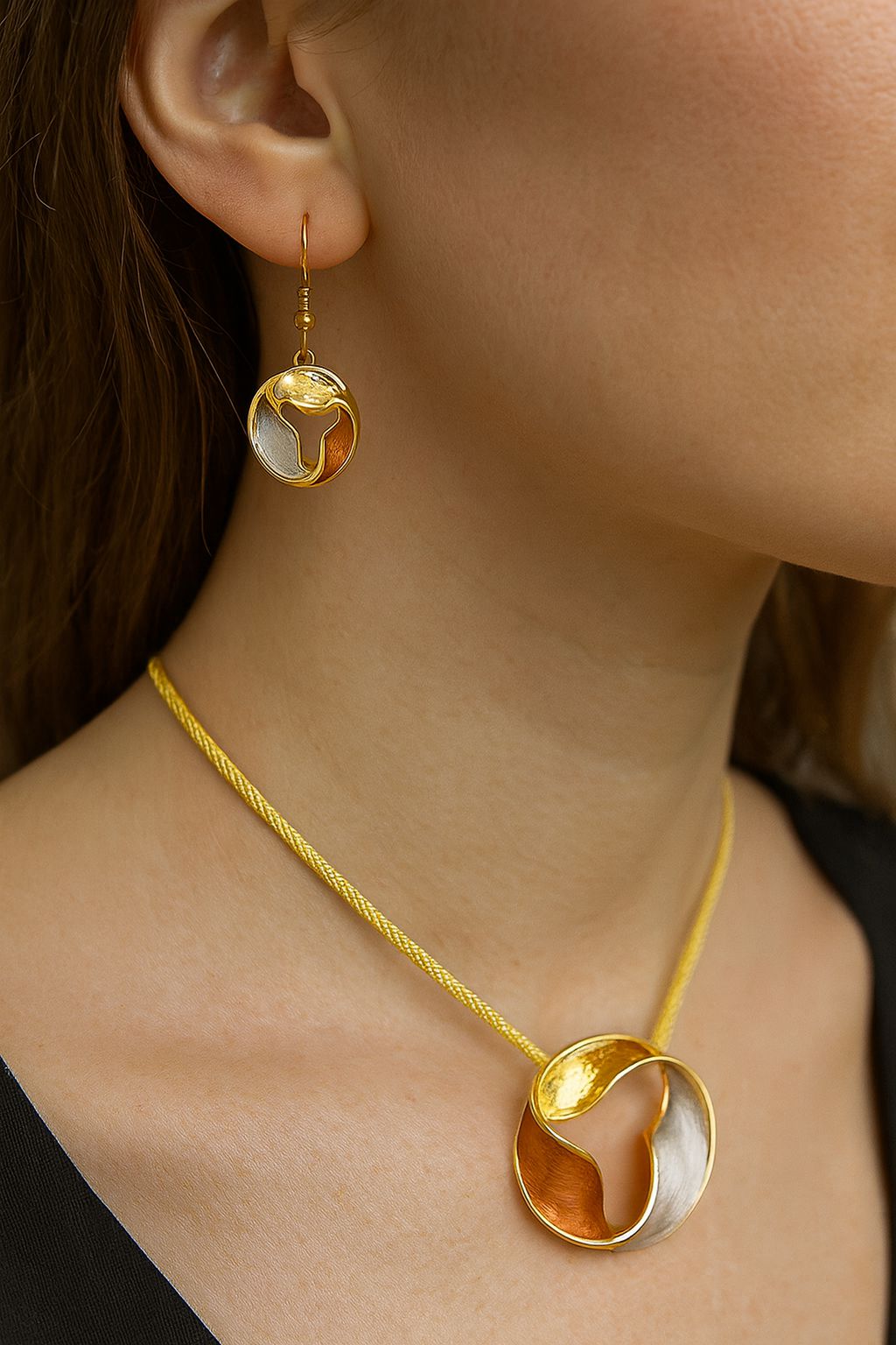 Close-up of hand-painted enamel drop earrings in gold