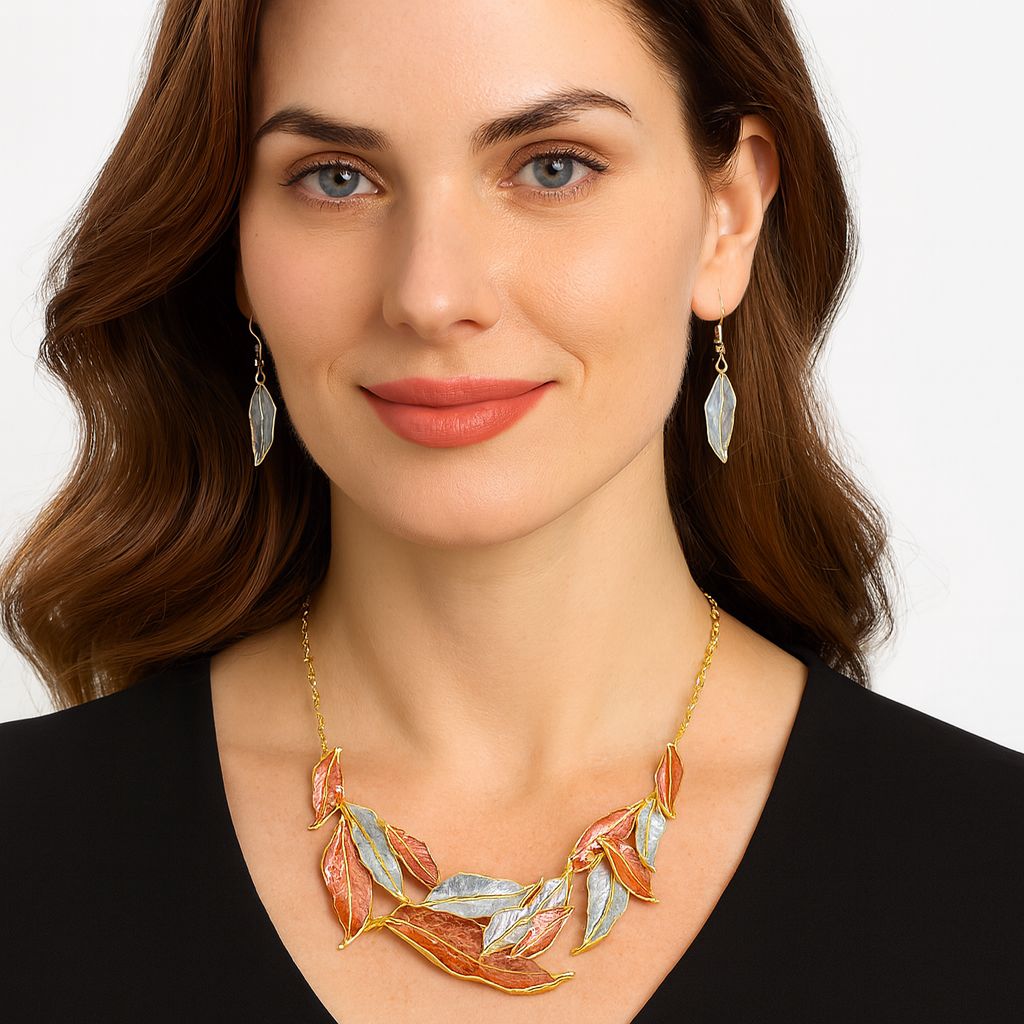 Model wearing artisan feather jewelry set in gold, silver, and copper tones