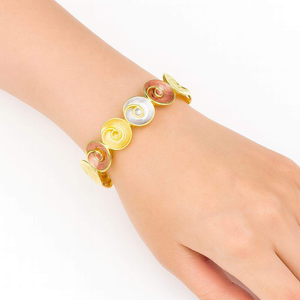 Handmade tri-color spiral disc bracelet with KC gold plating and swirl textures on wrist