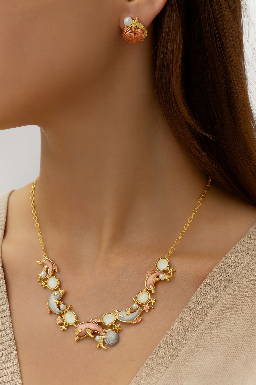 Hand-painted enamel dolphin necklace with matching shell earrings on model