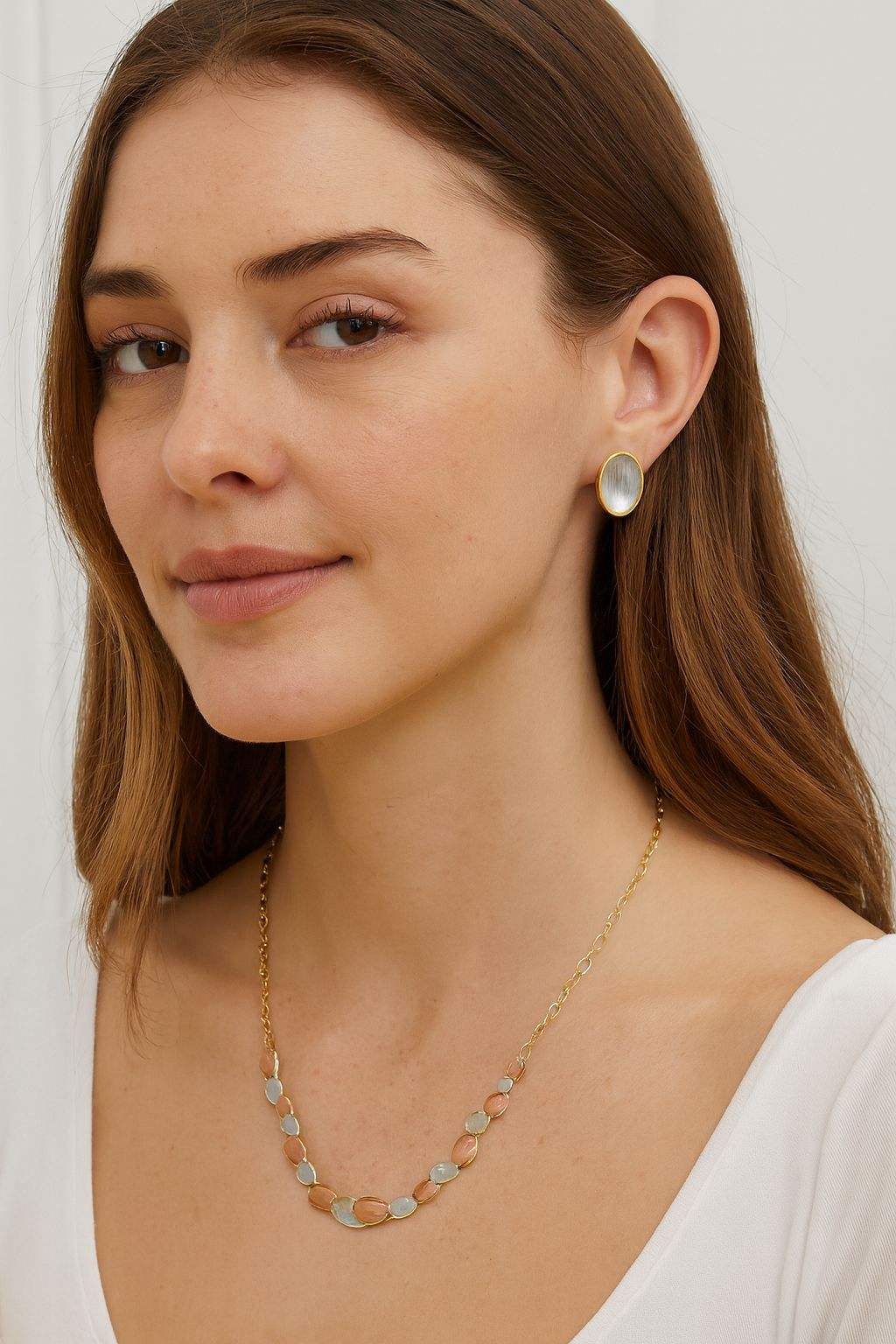 woman wearing gold oval necklace and matching oval stud earrings with multi-tone brushed finish