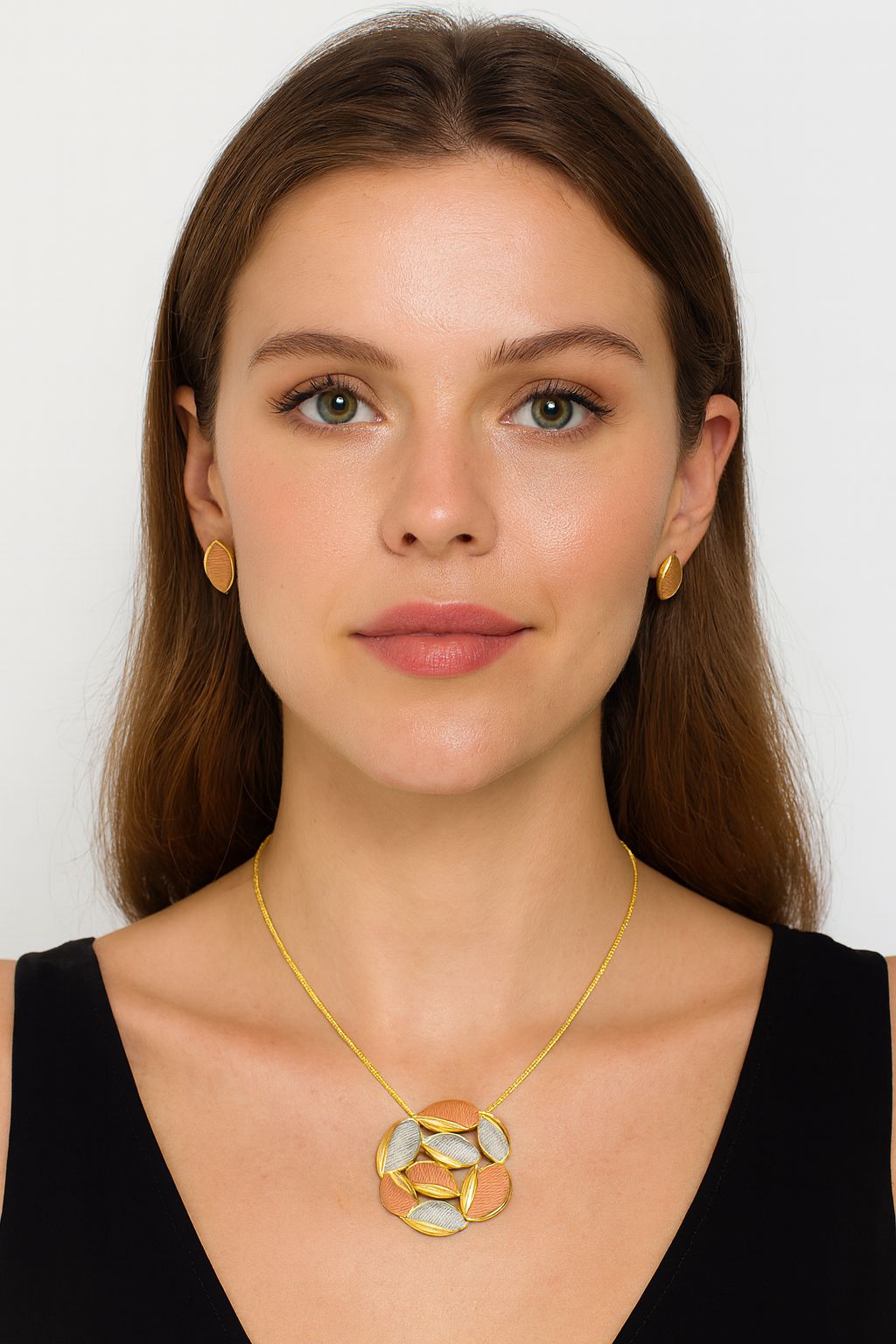 Model wearing gold plated tri-tone oval necklace and matching earrings