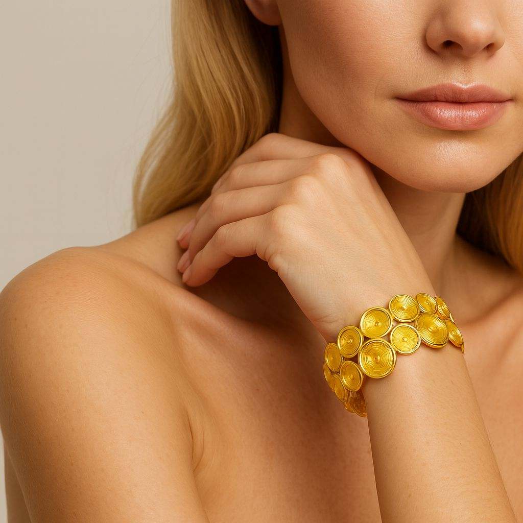 Woman wearing spiral layer KC gold plated bracelet with ripple design by Pallas Jewellery