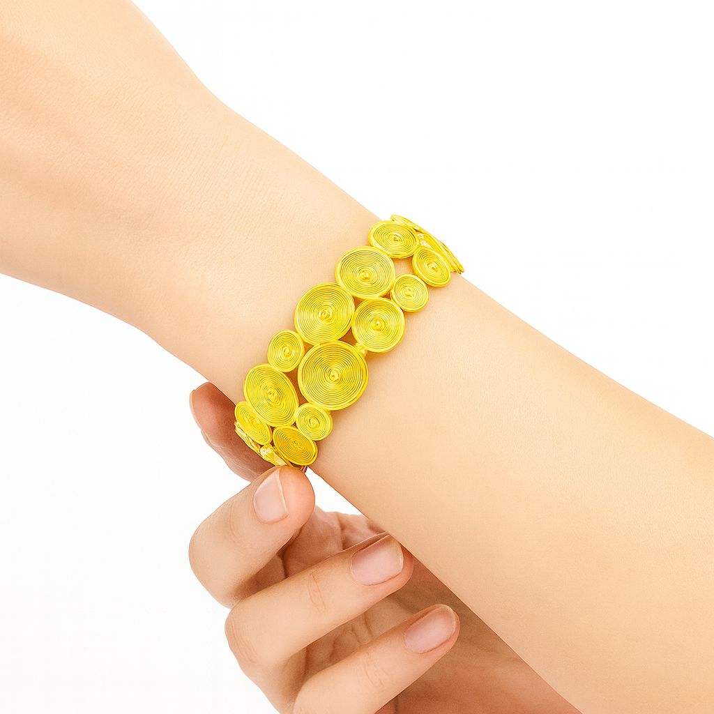 Spiral Layer KC gold plated bracelet with layered spiral discs and ripple texture on wrist