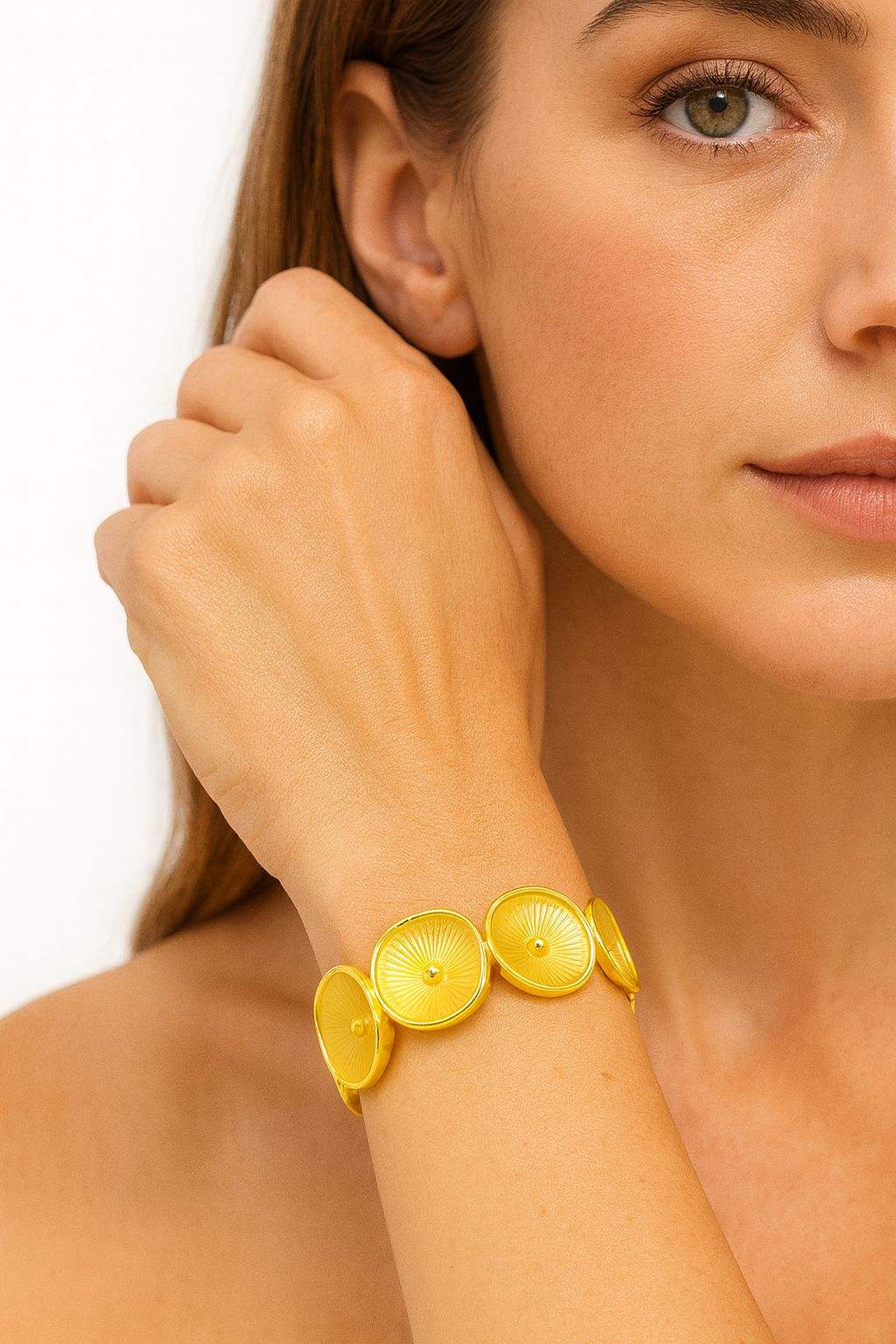 Radiant Sunburst KC gold plated bracelet with textured circular discs on woman's wrist