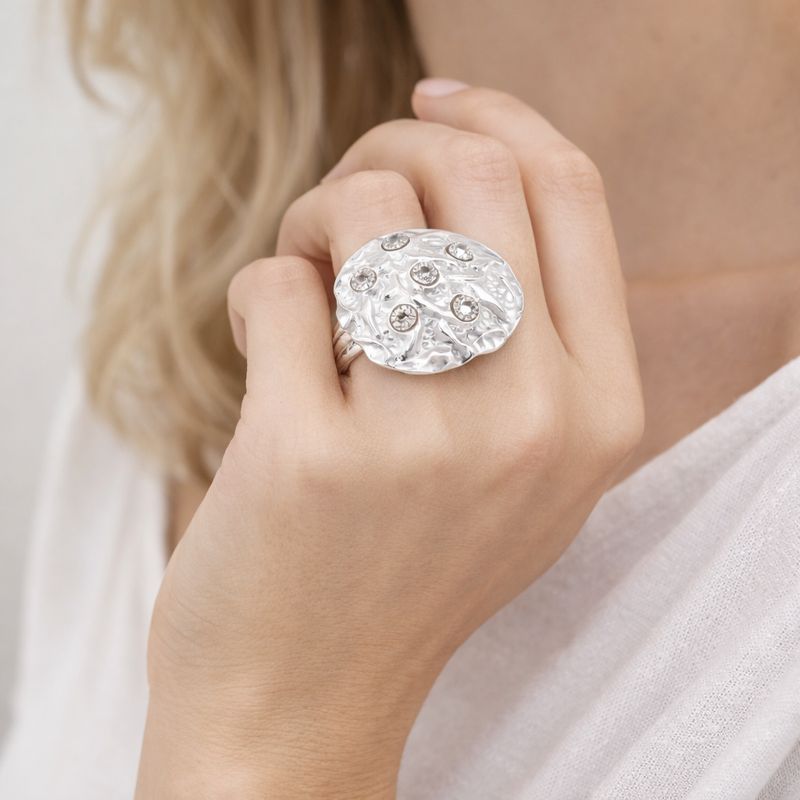Modern sculptural crystal silver ring worn by woman