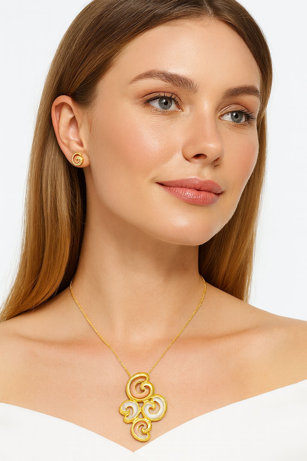 Model wearing swirl enamel jewelry set in gold and peach tones