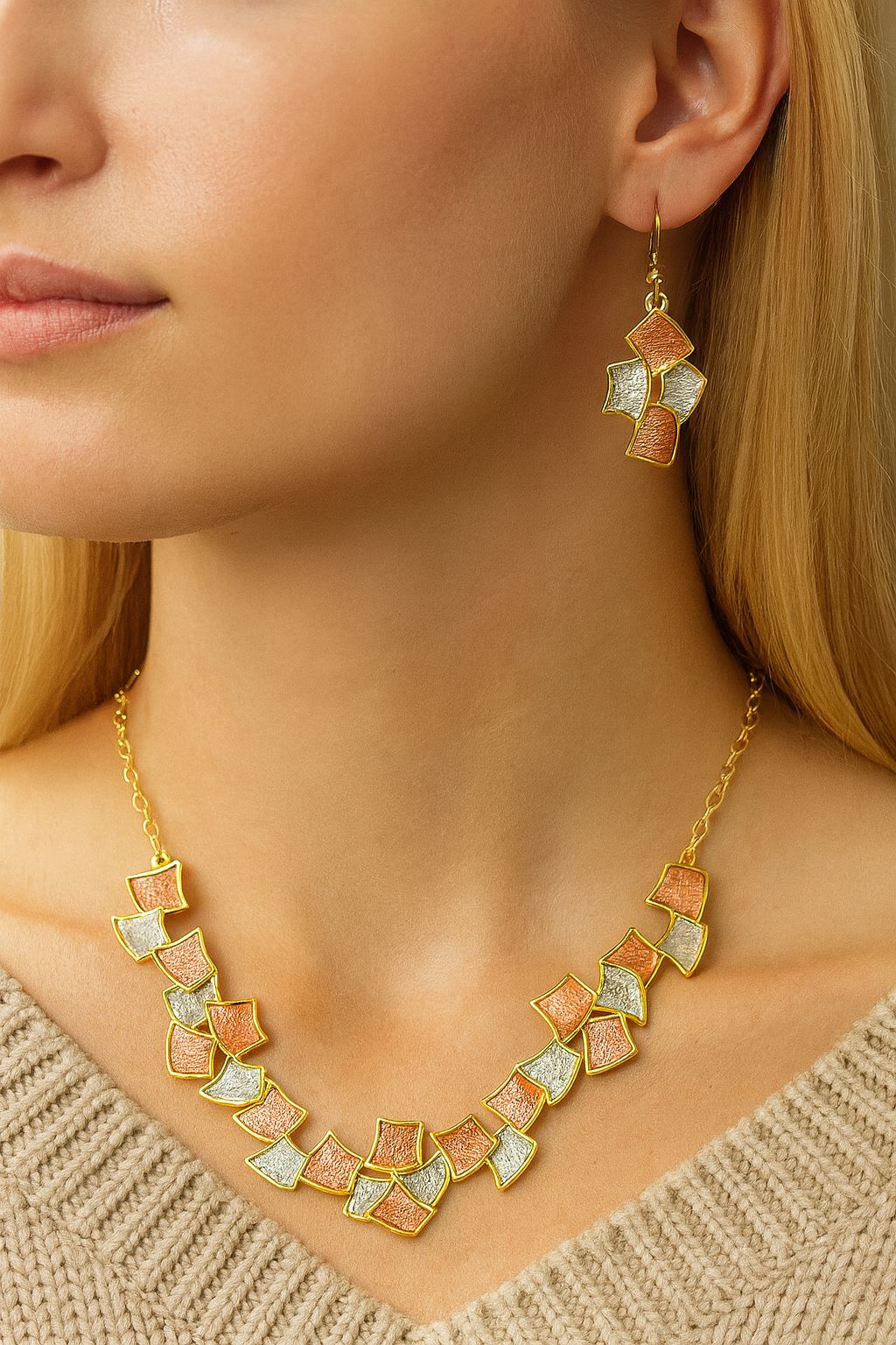 Model wearing geometric KC gold necklace and matching drop earrings