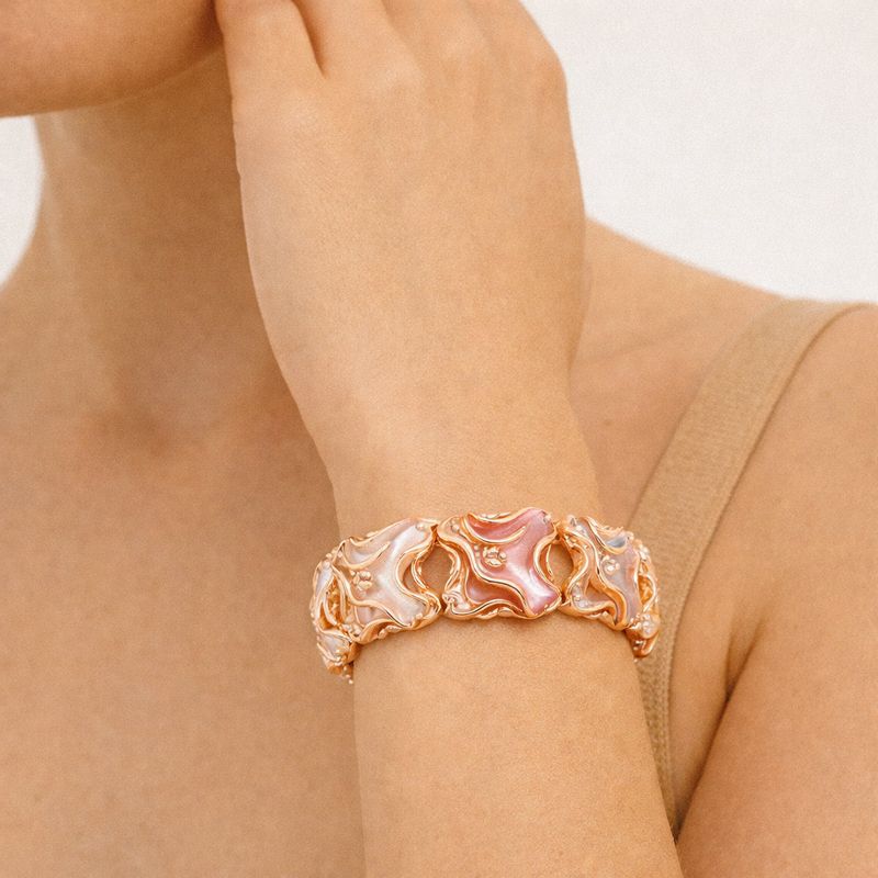 Close-up of gold plated enamel cuff with hand-painted details