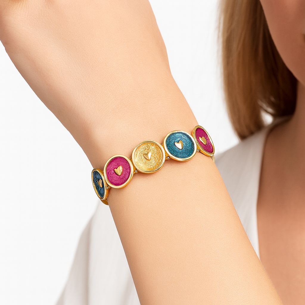 Women's gold plated enamel heart bracelet worn on wrist