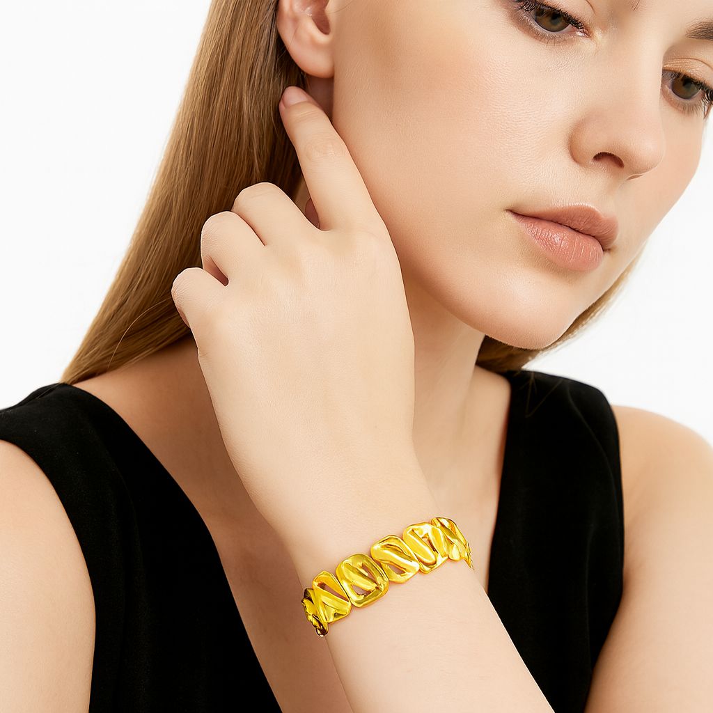 Gold plated geometric bracelet worn on female model wrist”