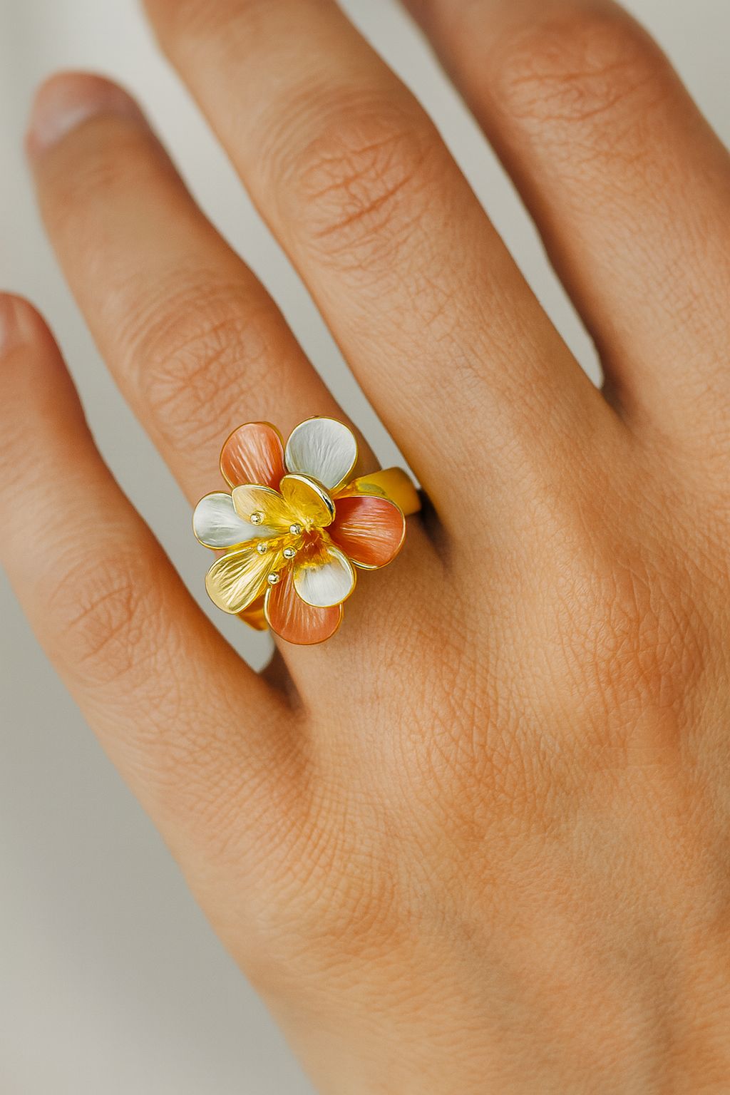 Artistic enamel flower ring worn on finger