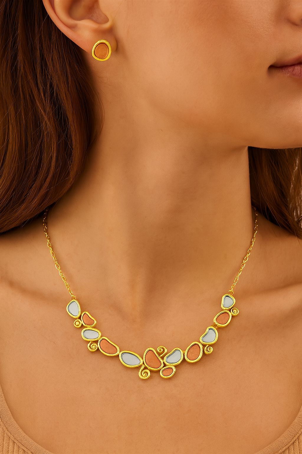Model wearing artistic gold plated enamel necklace and stud earrings