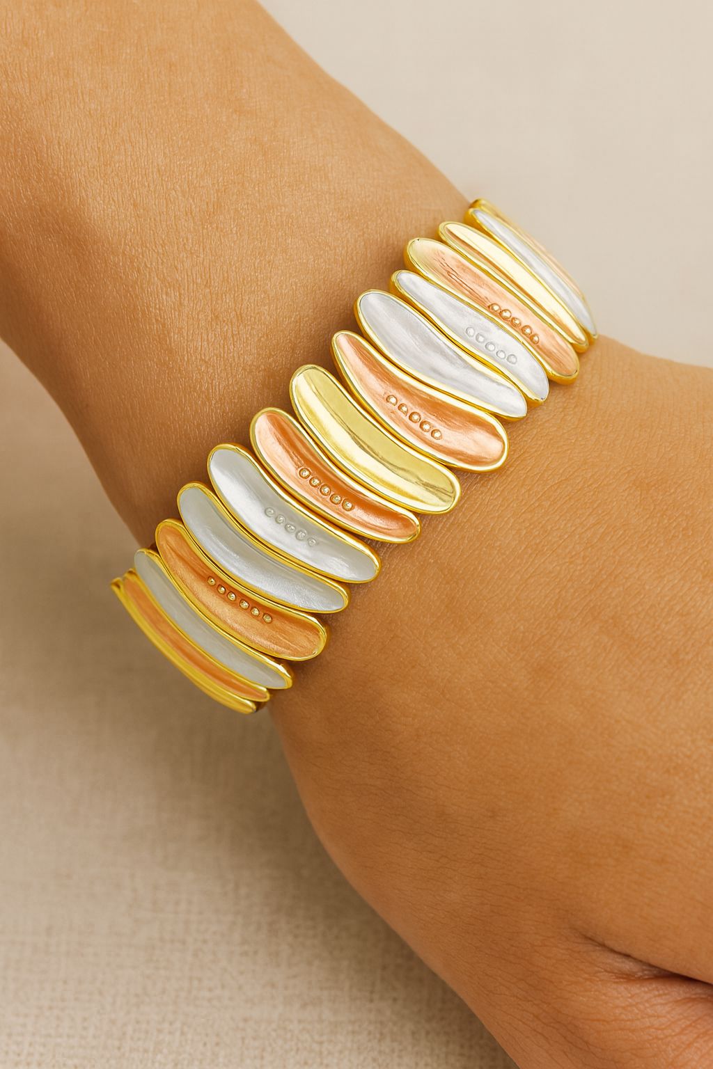 Model wearing gold floral bangle on wrist